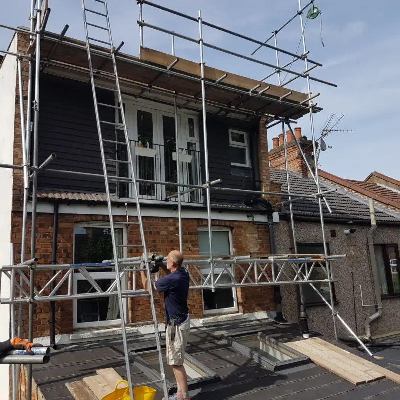 The Devlins Scaffolding team erecting scaffolding at the rear of a timber-clad house