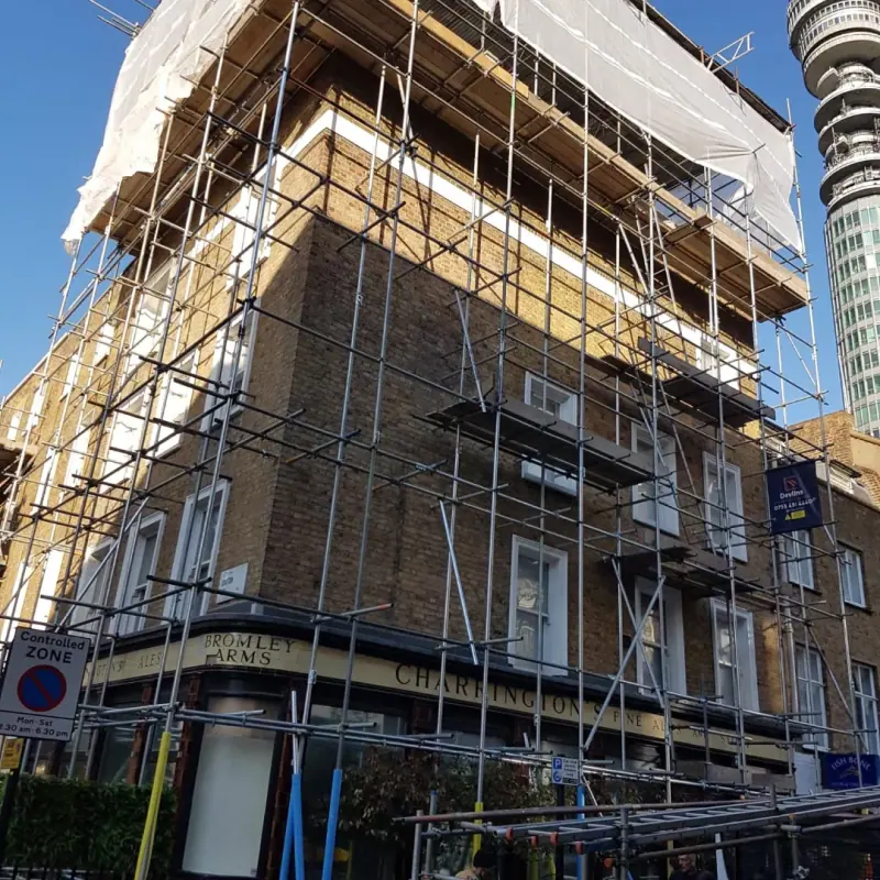 Edwardian terrace scaffold with BT Tower in skyline and Devlins board visible