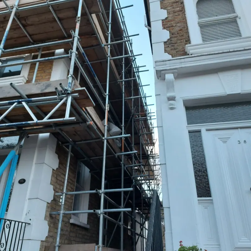 Dramatic up-angle view of full scaffold on painted Victorian terrace at 36–38
