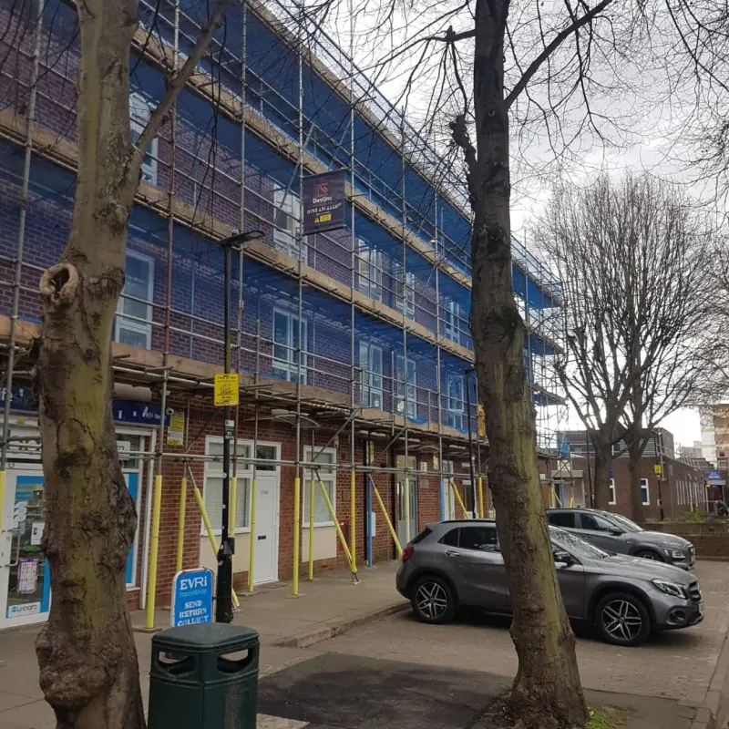 Council flats scaffolding in winter with bare trees in front