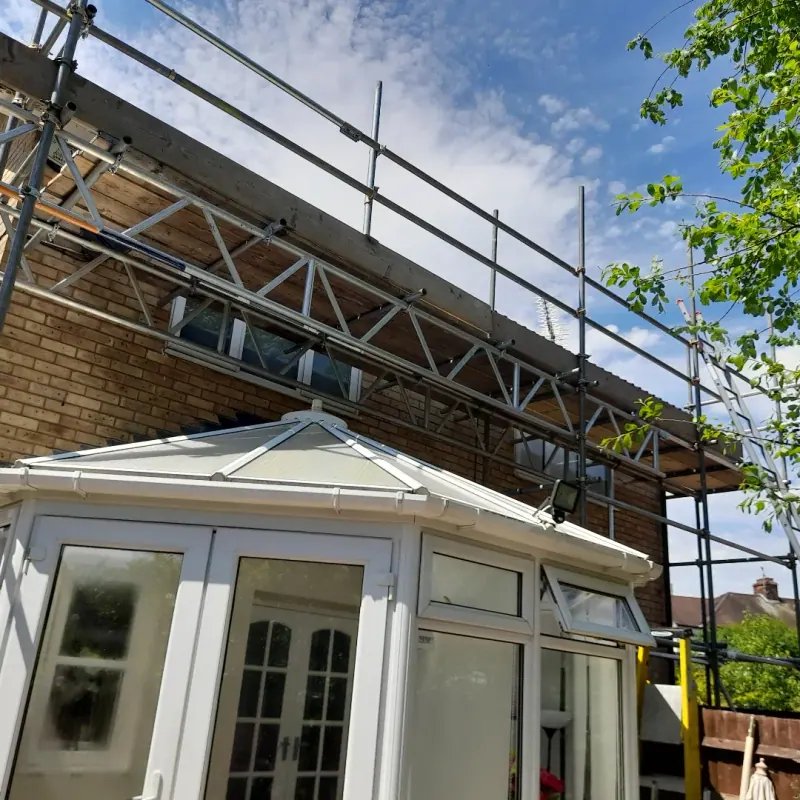 Low scaffolding for a rear extension and conservatory under a blue sky