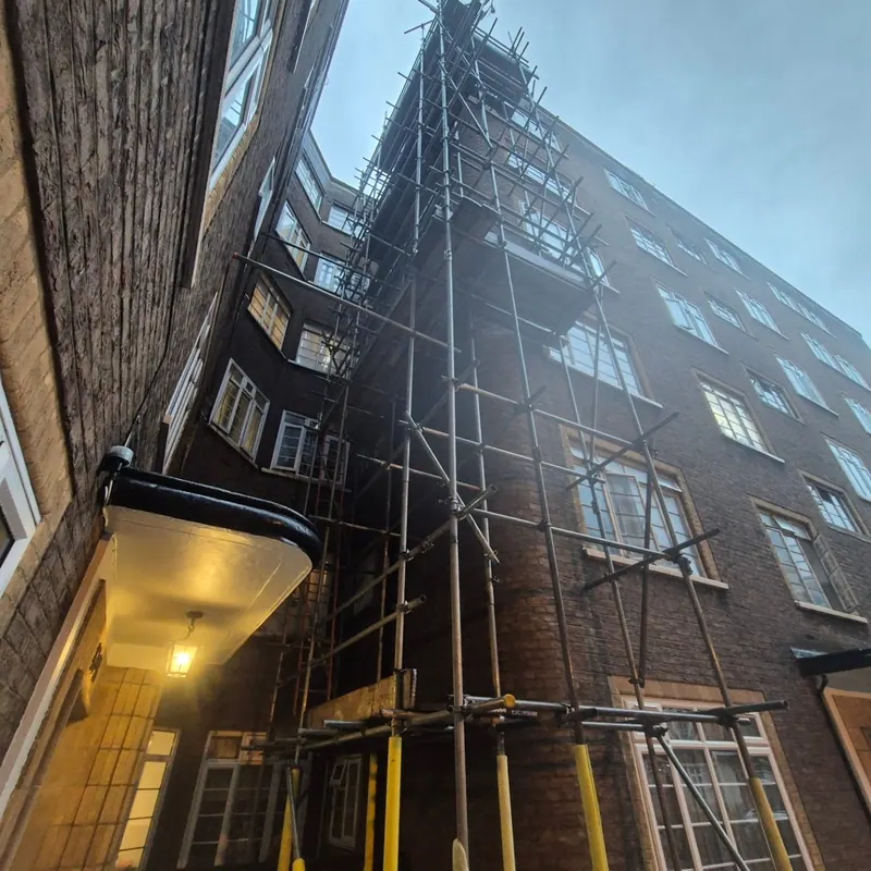 Tall vertical access scaffolding in a courtyard showing high-reach capability